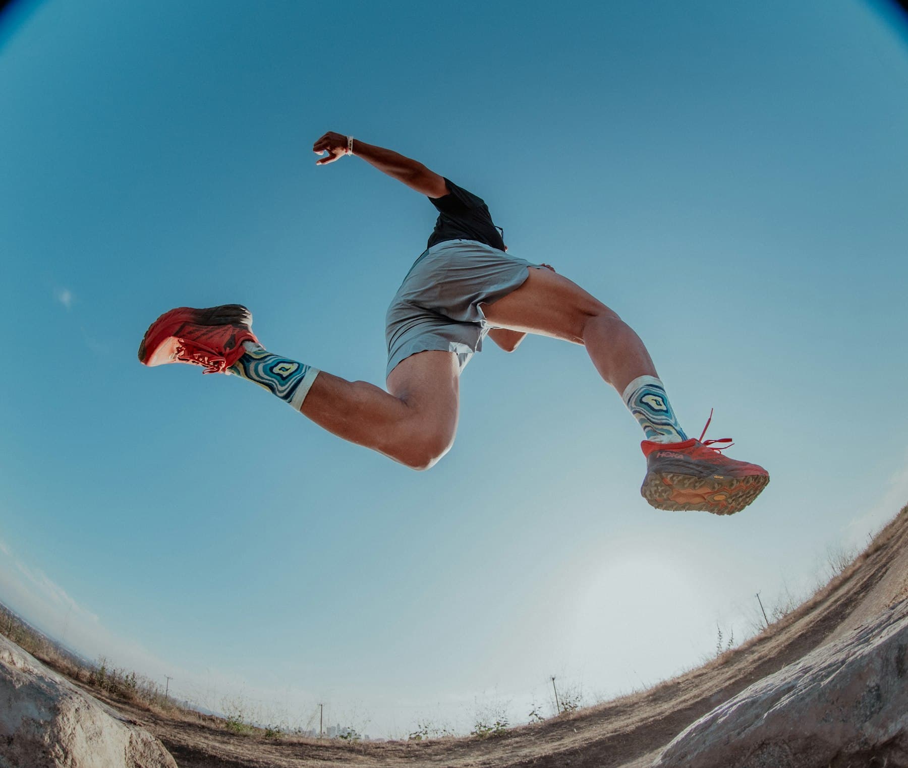 Athlete mid-leap against a blue sky