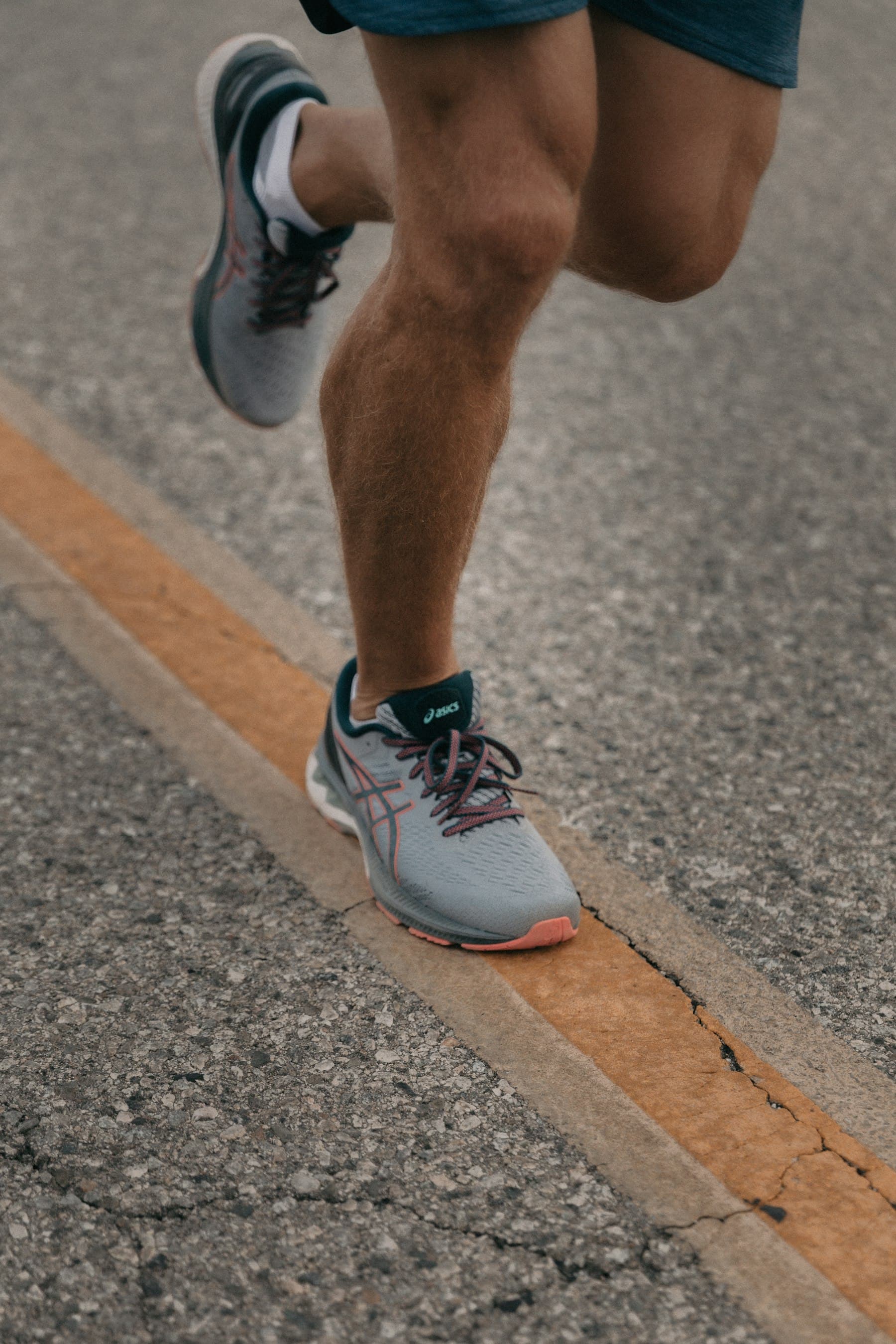 Close-up of a runner's shoes on an asphalt road